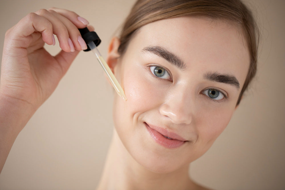 Woman applying prickly pear seed oil to her face with a dropper