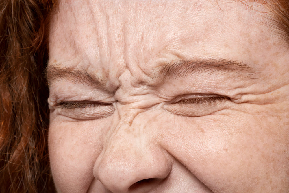 Close-up of woman squinting, showing facial wrinkles