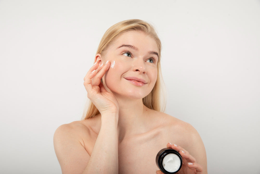 Woman applying tallow balm to face for skincare