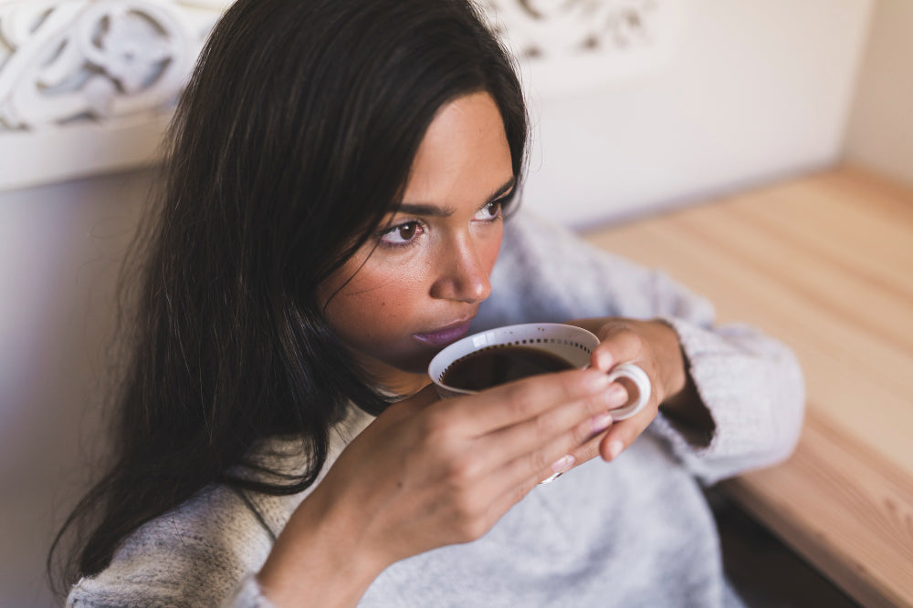 Woman drinking coffee for caffeine withdrawal symptoms