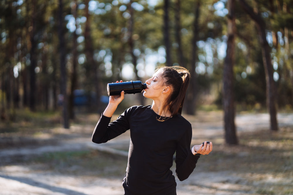 Woman drinking electrolyte powder during outdoor run