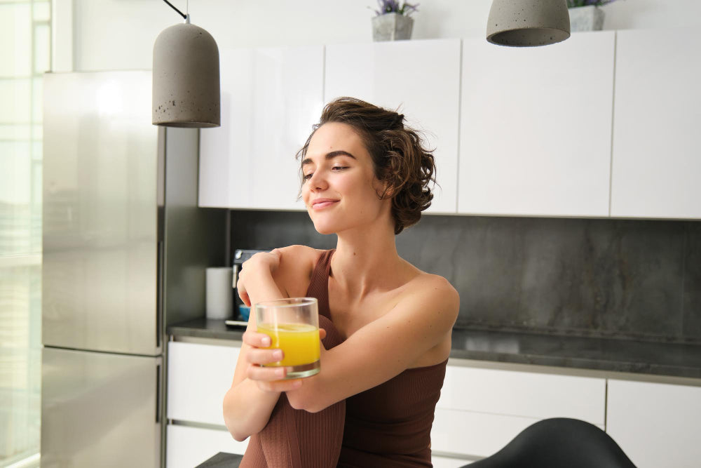 Woman enjoying a collagen drink in her kitchen 
