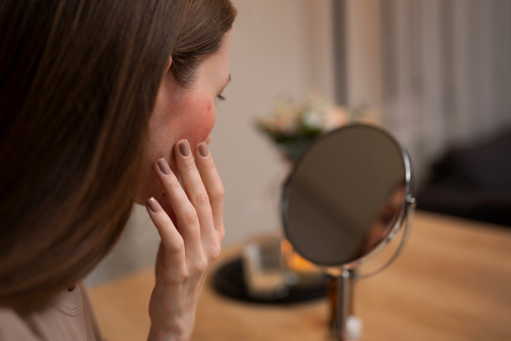 Woman examining red irritated skin in mirror