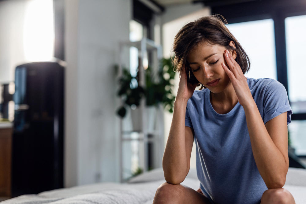 Woman holding her temples while experiencing a headache