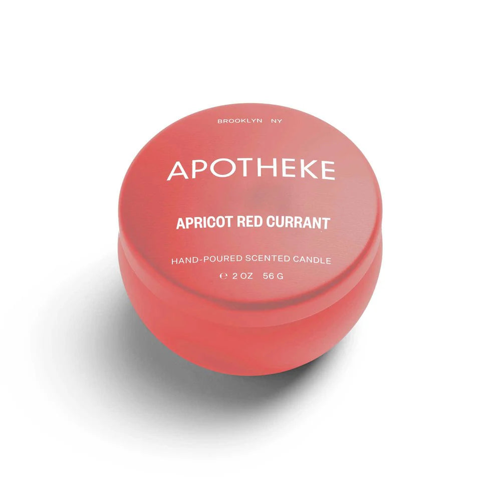 A mini tin candle in apricot red currant scent with pink packaging 