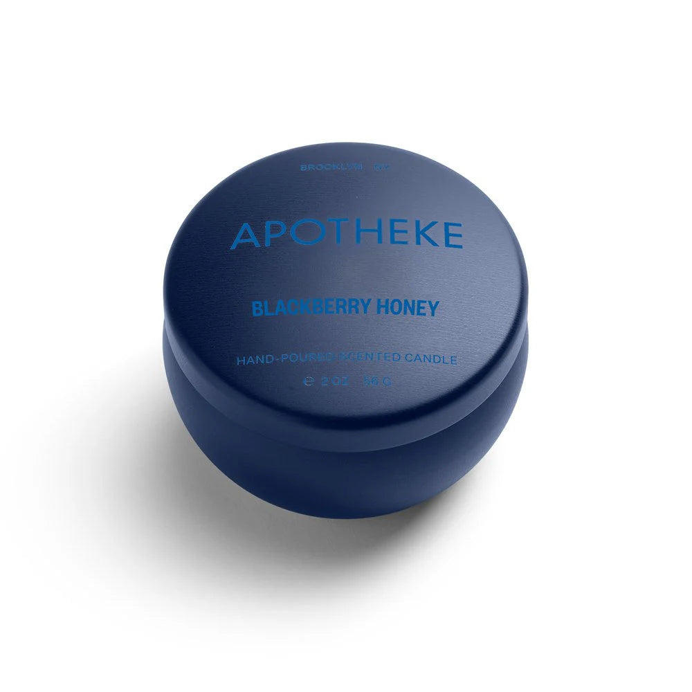 A mini tin candle in blackberry honey scent with dark blue packaging 