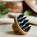Wooden brush with black bristles on a textured surface with blurred background