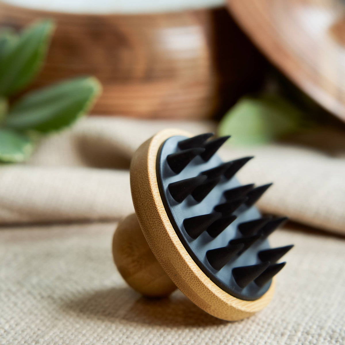 Wooden brush with black bristles on a textured surface with blurred background