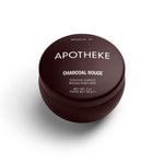 A mini tin candle in charcoul rouge scent with burgundy packaging 