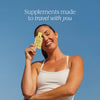 Cymbiotika Liposomal Vitamin D3 K2 CoQ10 lifestyle ad - smiling woman holding yellow supplement bottle against blue sky with text Supplements made to travel with you