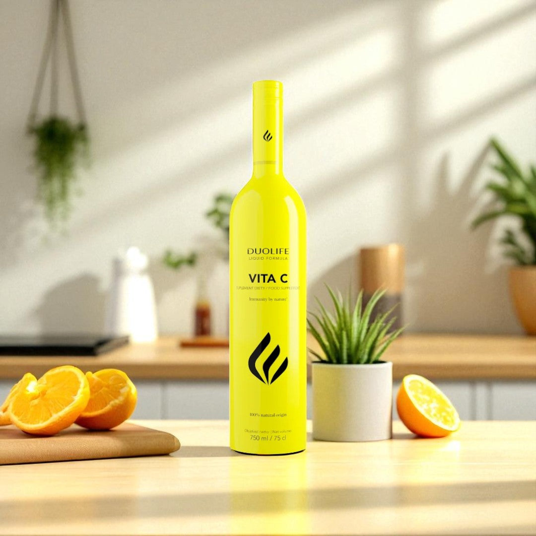 DUOLIFE Vita C bottle displayed on kitchen counter surrounded by fresh oranges and green plants, emphasizing natural vitamin C sources and wellness