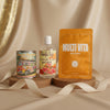 Good Life Box by Campus Rebel lifestyle photo featuring Peace On The Beach tin candle, Surfs Up Coconut Lime Body Wash, and LAPCOS Multi Vita Brightening sheet mask displayed on a wooden stand with beige silk backdrop