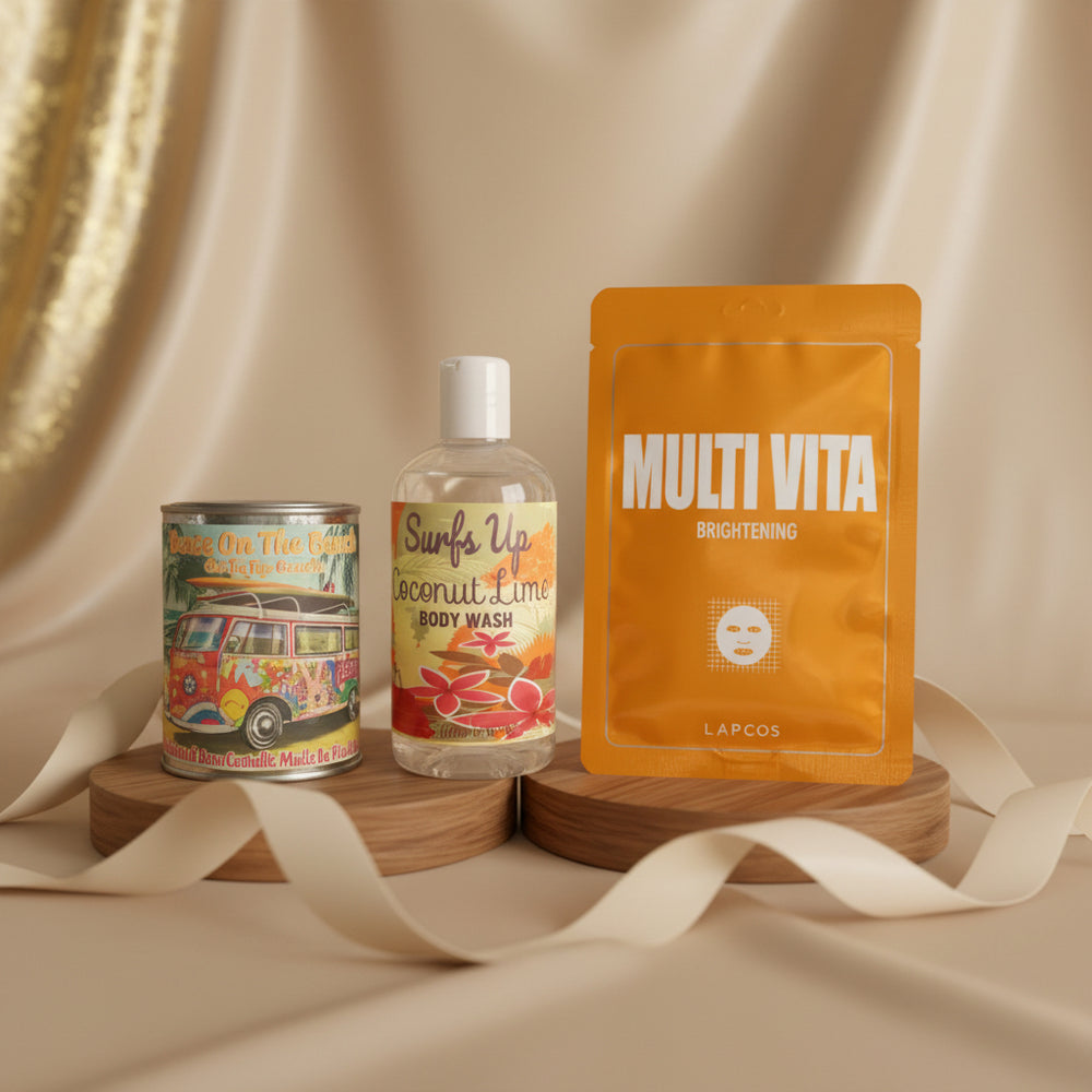 Good Life Box by Campus Rebel lifestyle photo featuring Peace On The Beach tin candle, Surfs Up Coconut Lime Body Wash, and LAPCOS Multi Vita Brightening sheet mask displayed on a wooden stand with beige silk backdrop