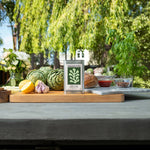 Table with fresh produce and a bottle of olive oil in an outdoor setting