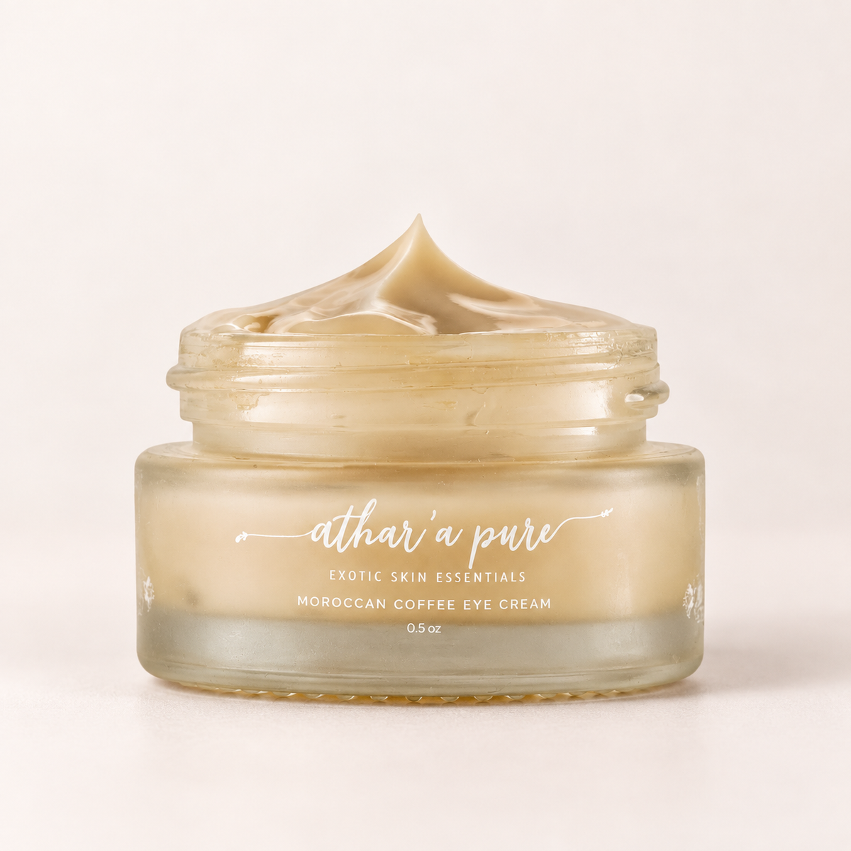 A glass jar of Athar'a Pure Moroccan Coffee Eye Cream with a swirled cream texture visible inside and on top of the open jar