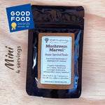 A black stand-up pouch of Roots Harmony Natural Living Mushroom Marvel Organic Superfood Powder, displayed on a light wood background with a blue 'Good Food Awards winner 26' badge and 'Mini 4 servings' text.