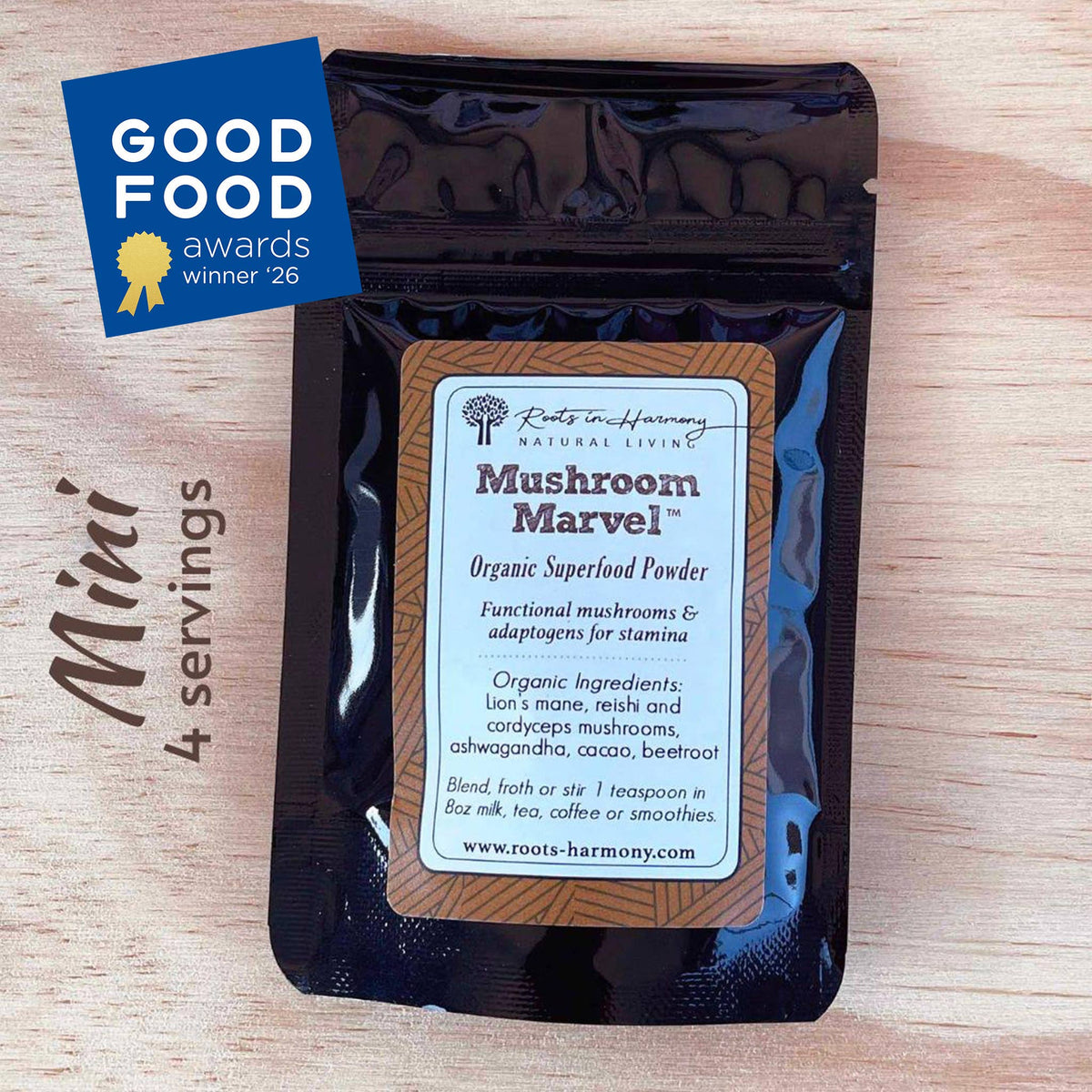 A black stand-up pouch of Roots Harmony Natural Living Mushroom Marvel Organic Superfood Powder, displayed on a light wood background with a blue 'Good Food Awards winner 26' badge and 'Mini 4 servings' text.