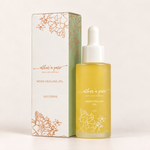 A bottle of aether & pure Neem Healing Oil next to its white and sage green packaging box, both featuring elegant copper-gold botanical illustrations