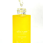 A bottle of Athar'a Pure Neem Healing Oil filled with bright yellow liquid, shown with a glass dropper above the open bottle
