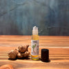 Pohala Oil of Olena Turmeric roll-on bottle displayed alongside fresh turmeric roots on a wooden surface with blue-grey background