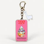 A metal keychain featuring a pink rectangular tin with 'WOO' branding and a colorful droplet illustration, alongside a small white llama charm on a gold-tone ring, shown on a plain white background.