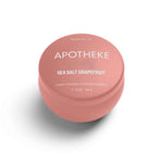 A mini tin candle in sea salt grapefruit scent with pink packaging 