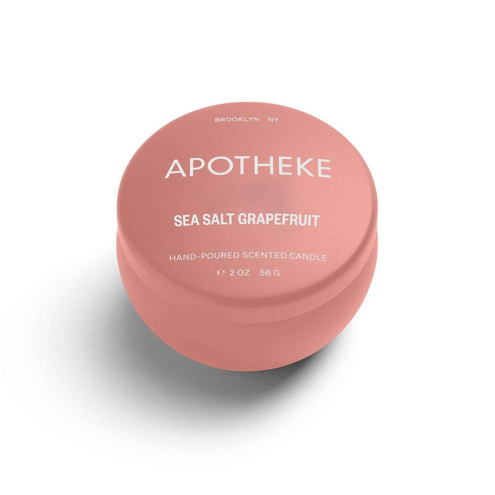 A mini tin candle in sea salt grapefruit scent with pink packaging 