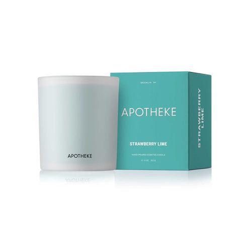 A white candle with a label that reads 'APOTHEKE Strawberry Lime Classic', along with the product's box which is also white and has text and branding.