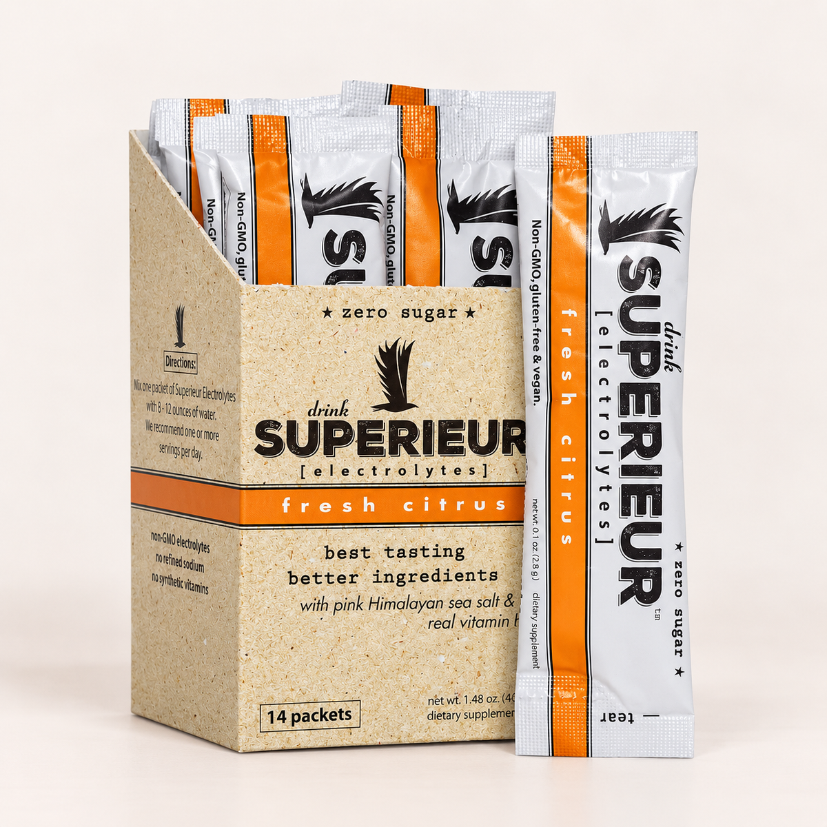 A box of drink superior electrolyte packets with several individual packets standing in front on a clean white background. The packaging is kraft paper with orange and white sections and black text.