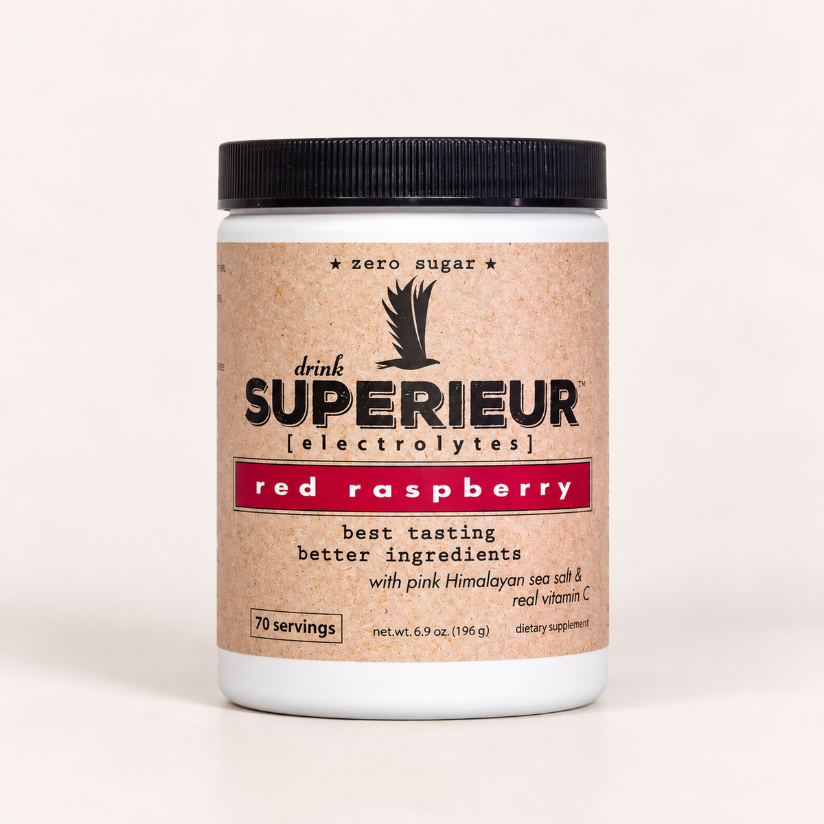A white plastic tub of drink SUPERIEUR electrolytes in red raspberry flavor, featuring a textured kraft paper label and a black ribbed lid, set against a plain off-white background.