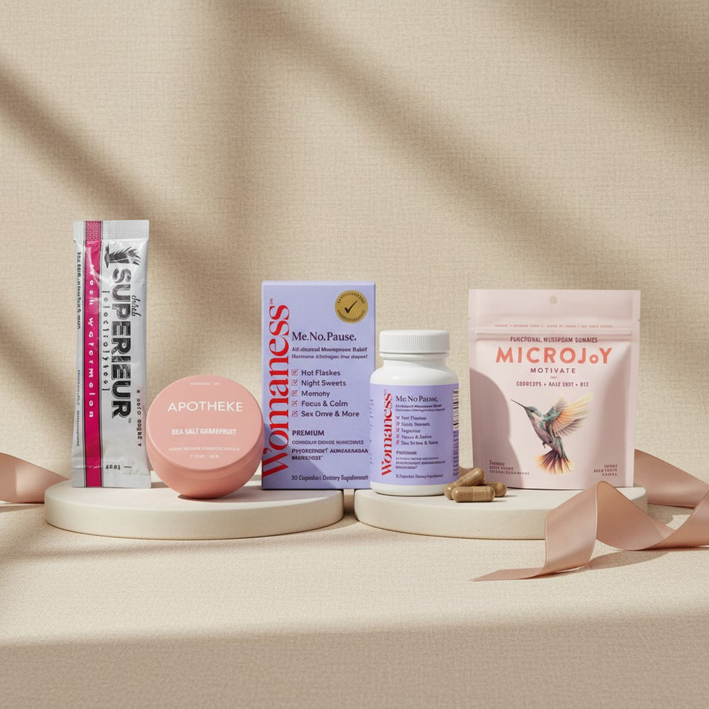 The Menopause Collection featuring Superieur strips, Apotheke Sea Salt Grapefruit balm tin, Womaness Me No Pause vitamins, and MicroJoy Motivate mushroom gummies arranged on platforms with ribbon on neutral background