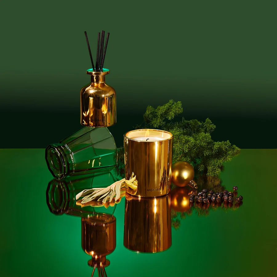 Apotheke mini candle and reed diffuser set in gold-colored specialty glasses, with a decorative patterned box, containing black rattan reed sticks.