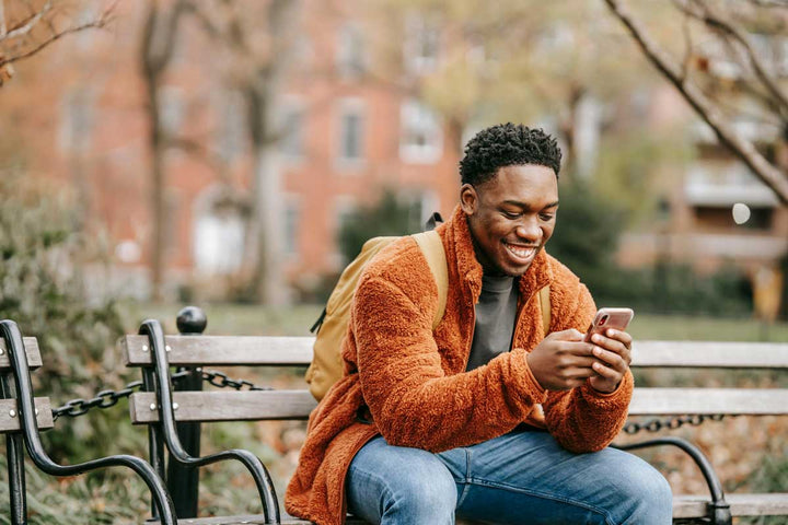 Smiling man looks on his cellphone.