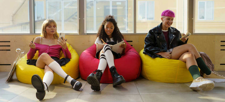 College students sit on multi-colored bean bag chairs.