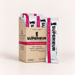 A box of drink SUPERIEUR electrolyte packets with one packet standing in front, photographed on a clean off-white studio background. 