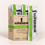 A box of Drink Superior Electrolytes lime blueberry packets stands next to a single individual packet on a clean, light beige background