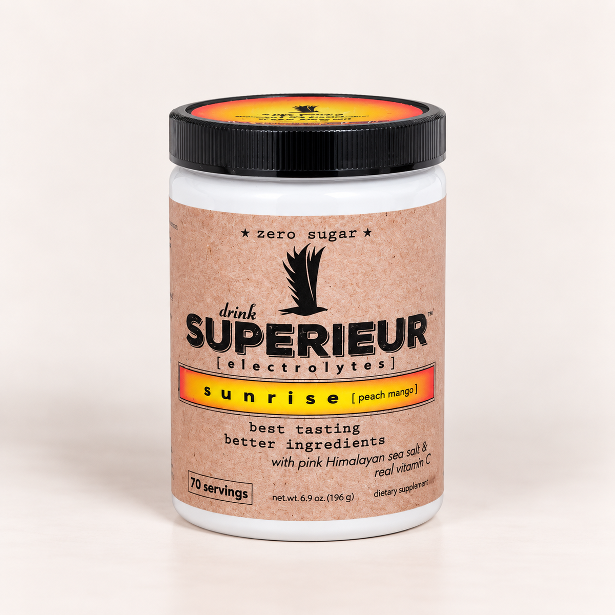 A white plastic tub of drink SUPERIEUR electrolytes in the sunrise (peach mango) flavor, featuring a kraft-paper style label and a black lid with a yellow and orange design.